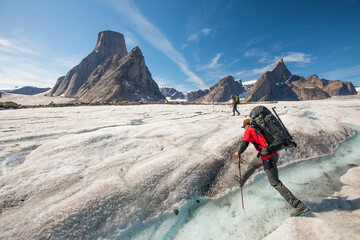 Mountaineer crosses a river on the Caribou Glacier, Baffin Island