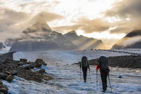 Backpackers on the move hiking toward iconic Mount Loki, Baffin Island