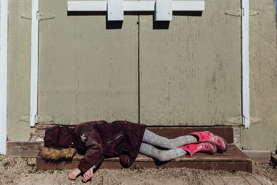 Young gilr lying on steps being bored