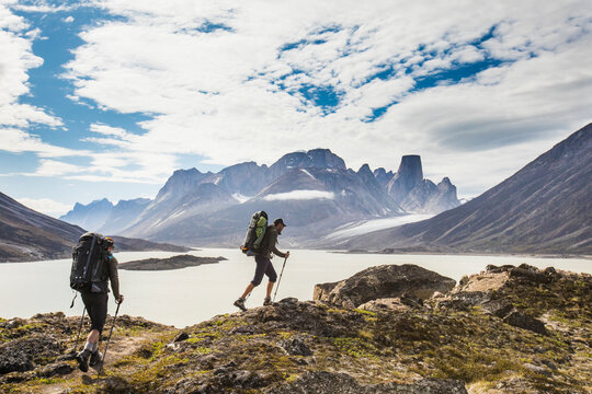 Two backpackers hiking through Akshayak Pass, Baffin Island, Canada.