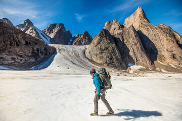 Backpacker hiking on glacier through Akshayak Pass, Baffin Island.