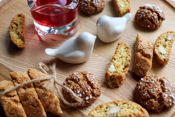 Traditional italian cantuccini cookies with almonds and dried cranberries with a glass of red sweet...