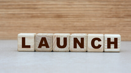concept of the word to LAUNCH on cubes on a light wooden background