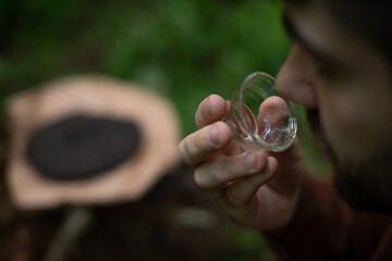 Man smelling glass tea bowl after tea ceremony outdoors 