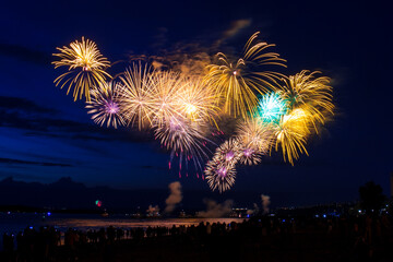 Celebratory fireworks in the night sky over the Volga river opposite the embankment in Samara city