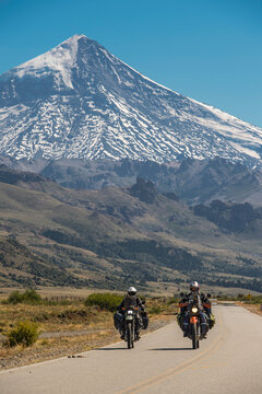 Couple on touring motorbikes. Lanin volcano in the back, Argentina