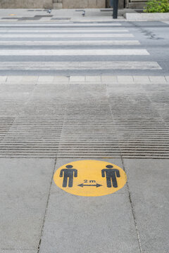 a two meters social distance sign drawn on the ground during the coronavirus pandemic