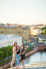 Fototapeta na wymiar Family on rooftop enjoying with view of beautiful sunset in Sankt Petersburg in Russia