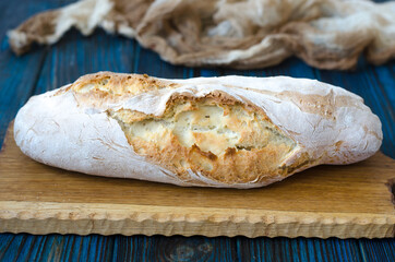 Crispy baguette with cracks on the board