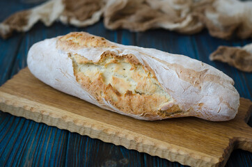 Crispy baguette with cracks on the board