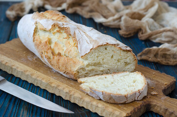 Crispy baguette with cracks on the board