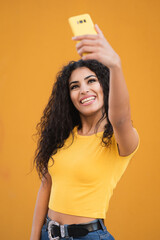 Funny mixed race girl taking selfies pictures with her smartphone 