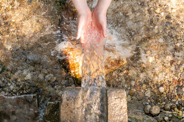 hands in water on real spring in the nature
