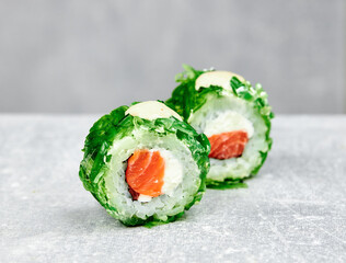 two pieces of sushi roll uramaki with salmon, cheese and chuka