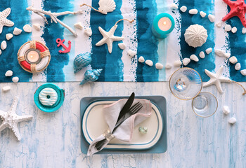 Columbus Day lunch table setting with nautical sea decorations on blue stripy runner, classic blue...