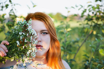 Beauty young girl with red hail and natural flowers