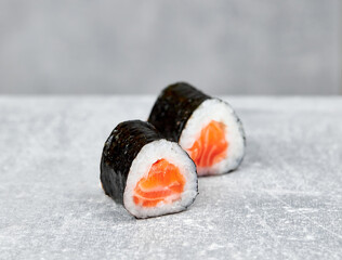 two slices of mini salmon roll sushi maki