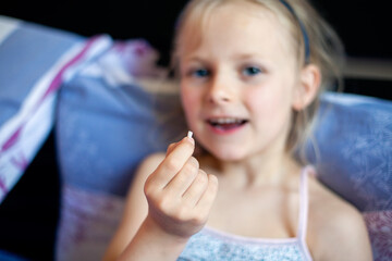 A beautiful little girl of 6-7 years old lost the first milk tooth. Loss of primary teeth, replacement of teeth with permanent ones. Children's dentistry. Beautiful baby teeth