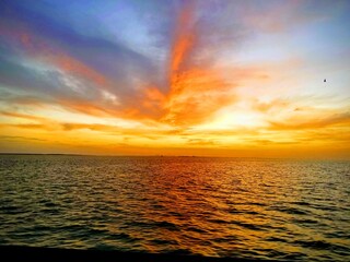 Fototapeta premium Looking at the sunset in the Gulf of Mexico in Galveston, Texas. Peaceful, colorful sunset at dusk.