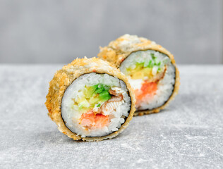 two slices of sushi roll tempura america baked with eel, salmon, cheese, avocado, tobiko caviar