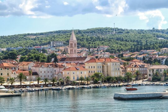 Supetar town on Brac island, emerald green ocean waters with palm trees. Supetar, Brac, Croatia, Europe. 