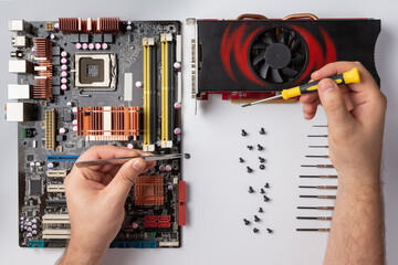 craftsman hands hold tools on the background of computer parts