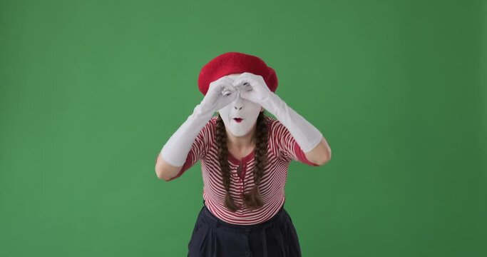 Amazed mime artist woman looking at something interesting with handmade binoculars