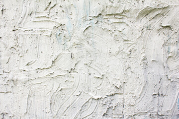 White rough stucco plaster strokes on a wall texture background.