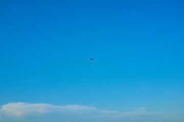 Fototapeta premium Hang glider with engine over blue sky