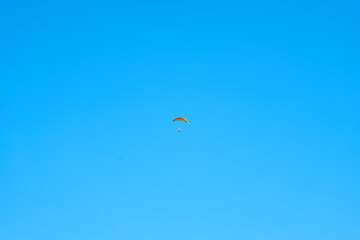 Hang glider with engine over blue sky