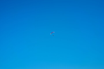 Fototapeta na wymiar Hang glider with engine over blue sky