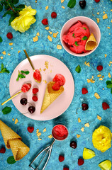 Summer ice cream berry sorbet preparation with waffle cones and fresh berries. Top view creative layout flat lay vertical orientation.