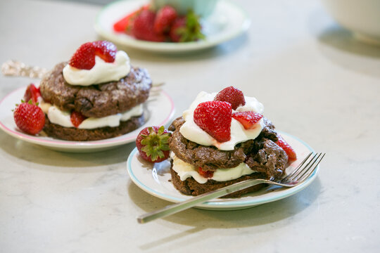 chocolate shortcake with strawberries and cream on plates with fork