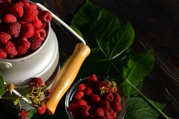 ripe, bright and fragrant raspberries with green leaves in early summer
