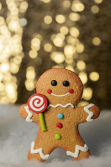 single decorative gingerbread man on a gold glitter and sequin background that sparkles and has lots of copy space
