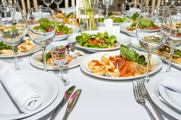 served and set table with dishes and utensils, white tones in the restaurant before the banquet
