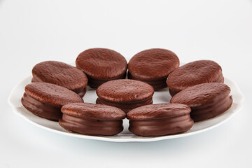 chocolate-coated cookies on a plate, isolate on a white background