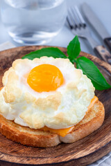 Trendy cloud or fluffy egg dish on  wooden plate, vertical