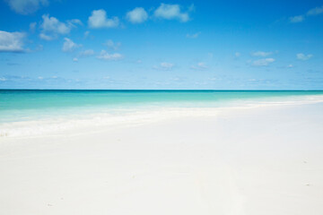 Clean white sand beach with turquoise water . Tropical island background. Small waves crushing on the beach.  Zanzibar island 