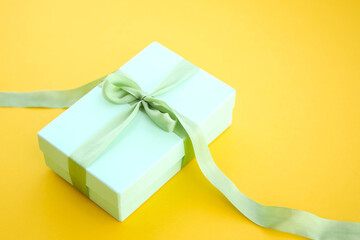 Girl holds a gift box and unties the bow. a girl opens a gift box. Gift box on a red background....