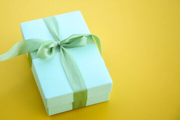 Girl holds a gift box and unties the bow. a girl opens a gift box. Gift box on a red background. Girl unties the tape from the box.
