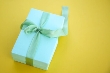 Girl holds a gift box and unties the bow. a girl opens a gift box. Gift box on a red background. Girl unties the tape from the box.
