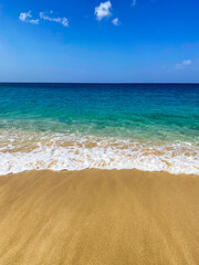 Waves lapping beach sand on island of Bequia in the Caribbean