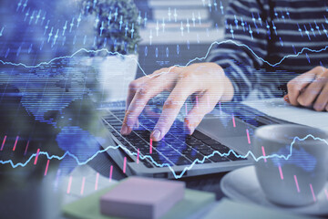 Double exposure of woman hands typing on computer and forex chart hologram drawing. Stock market invest concept.