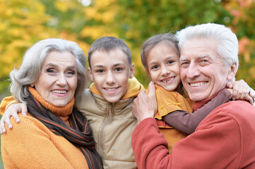 Fototapeta premium Happy grandfather, grandmother and grandchildren in park