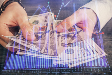 Multi exposure of financial graph drawing hologram and USA dollars bills and man hands. Analysis concept.