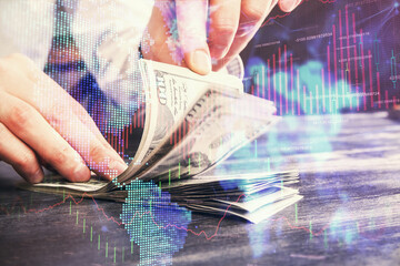 Multi exposure of forex graph drawing hologram and USA dollars bills and man hands. Technical Analysis concept.