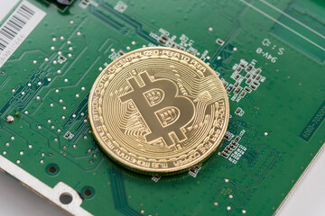 Gold Bitcoin on green chipset. Close-up, macro shot.
