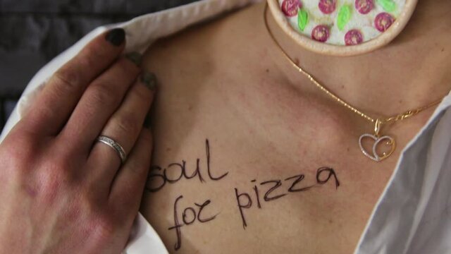 Girl with catkins in the form of pizza. On the chest of the girl is the inscription soul for pizza. Pizza advertisement