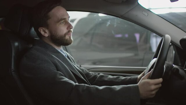 Driving car handsome man sitting in the car on a driver's seat and honking in the car. Businessman shouting hile sitting in a car.